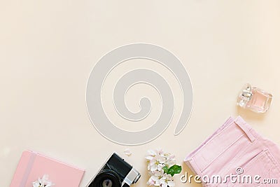 Workspace of a fashion blogger with a notebook, a camera, white flowers, clothes on a light background. Flat banner or store title Stock Photo