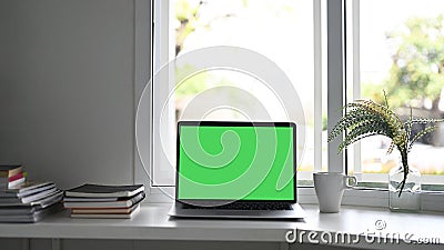 Workspace laptop computer with green screen. Stock Photo