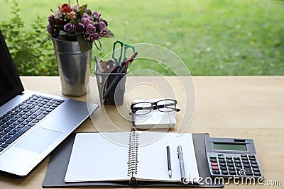 Workspace relaxing chill out work for office and laptop computer, Calculator and other stationary on wood table with green garden Stock Photo