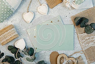 Workspace. Wedding invitation cards, craft envelopes, pink and red roses and green leaves on white background. Stock Photo