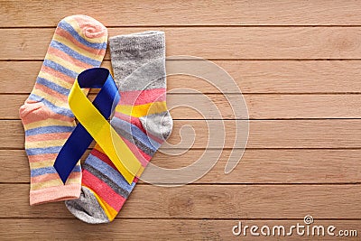World Down syndrome day background. Down syndrome awareness concept. Socks and ribbon on wooden background Stock Photo
