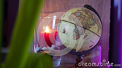 World earth globe in a decorated room with LED back lighting and candle light. Stock Photo