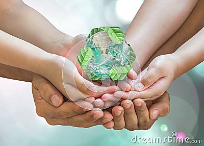 World environment day and ecology concept with family`s hands saving green planet with recycle sign. Stock Photo