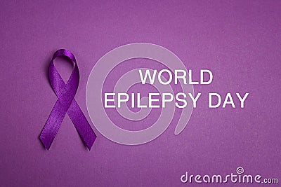 Purple epilepsy awareness ribbon on a purple background Stock Photo