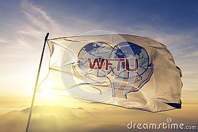 World Federation of Trade Unions WFTU flag textile cloth fabric waving on the top sunrise mist fog Editorial Stock Photo