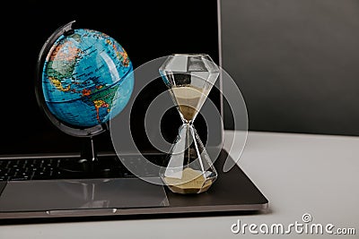 World globe with laptop and hourglass. Online business and globalisation theme Stock Photo