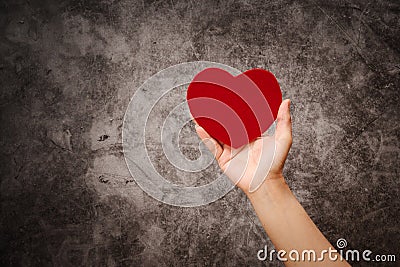 World health day, women hand hold red heart on grunge black background Stock Photo