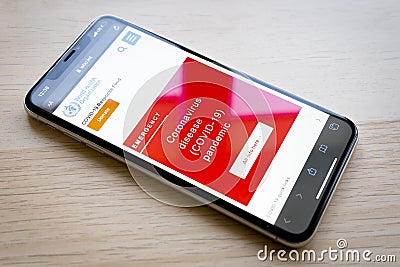 World Health Organization page on phone screen top view. Covid-19 or Coronavirus info on Who.int website, red warning screen of Editorial Stock Photo