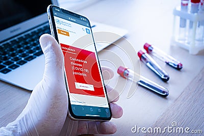 World Health Organization page on phone screen top view. Covid-19 or Coronavirus info on Who.int website, red warning screen of Editorial Stock Photo