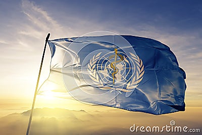 World Health Organization WHO flag textile cloth fabric waving on the top sunrise mist fog Editorial Stock Photo