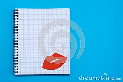 World Kiss Day. Red lips on a blank sheet of open notebook on a blue background Stock Photo