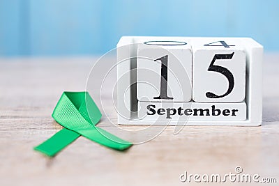 World Lymphoma Awareness Day, September 15th of white calendar and Green Ribbon for supporting people living and illness. Stock Photo