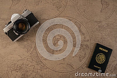 World map with analog reflex camera and Mexican passport, representing traveling the world with necessities Stock Photo