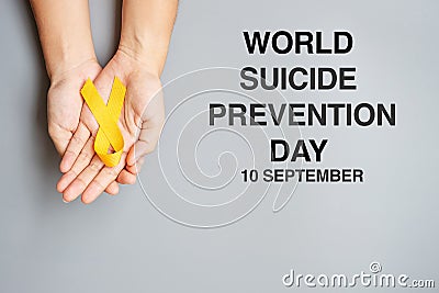 World Suicide prevention Day, hand holding Yellow Ribbon for supporting people living and illness Stock Photo