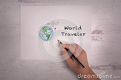 World Traveler message on paper with real hand holding pencil doodle of earth and a airplane flying around the world Stock Photo