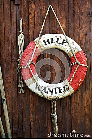 A worn life saver with the caption Help Wanted Stock Photo