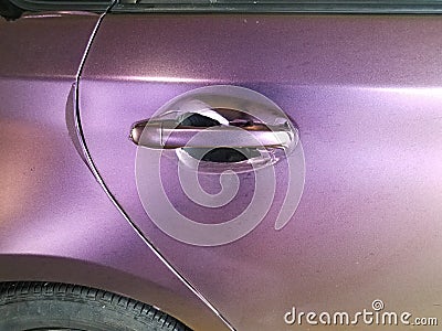 Worn purple wrap on automobile with door handle Stock Photo