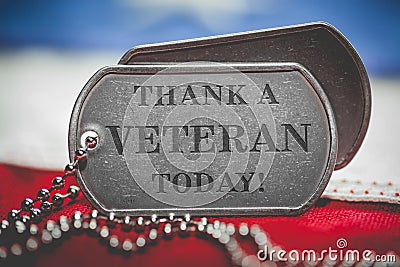 Worn US American dog tags on USA flag with Thank a Veteran Today text Stock Photo