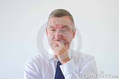 Worried anxious businessman with hand to chin Stock Photo