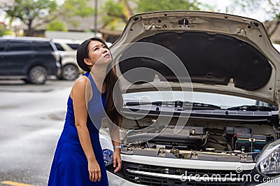 Worried Asian Japanese woman in stress stranded on street roadside with car engine failure having mechanic problem needing repair Stock Photo