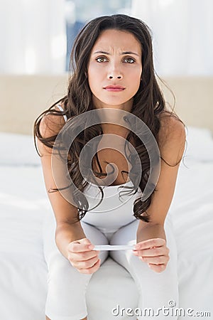 Worried Brunette waiting on pregnancy test Stock Photo