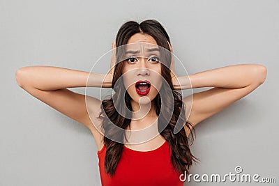 Worried brunette woman in casual clothes covering her ears Stock Photo