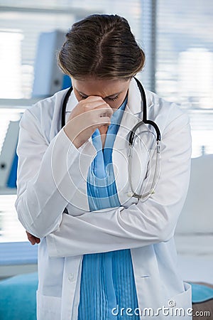 Worried doctor standing with hand on head Stock Photo