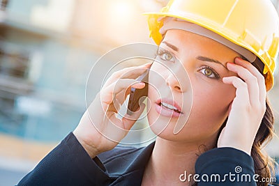 Worried Female Contractor Wearing Hard Hat on Site Using Cell Ph Stock Photo