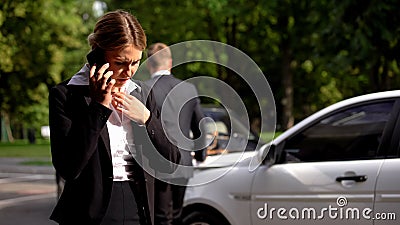 Worried female driver calling police by smartphone, traffic collision stress Stock Photo