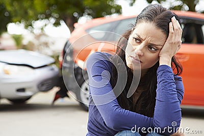 Worried Female Driver Sitting By Car After Traffic Accident Stock Photo