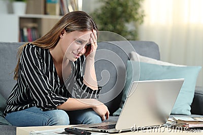 Worried homeowner checks laptop news Stock Photo