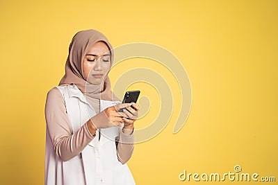 worried muslim woman in hijab using a cell phone Stock Photo