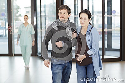 Worried pregnant woman and husband at hospital lobby Stock Photo