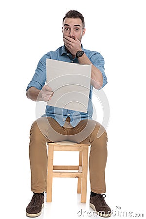 Worried smart casual man reading newspaper and gasping Stock Photo