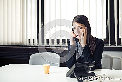 Worried stressed depressed office worker business woman receiving bad news emergency phone call at work.Looking confused Stock Photo