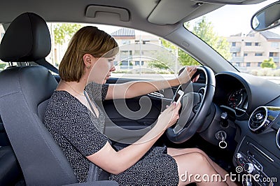 Worried and stressed woman driving car while texting on mobile phone distracted Stock Photo