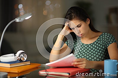 Worried student in the night trying to memorize notes Stock Photo