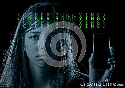 Worried teenager holding mobile phone as internet cyber bullying Stock Photo