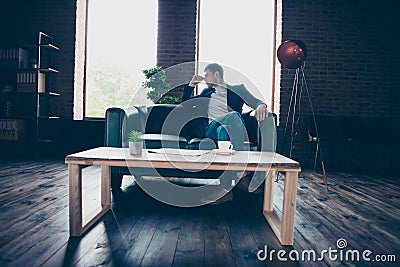 Worried tired bored stylish handsome classy guy top manager sitting on divan thinking about profit salary result growth Stock Photo