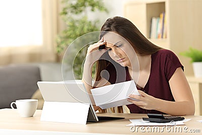 Worried woman calculating accountancy reading a letter Stock Photo