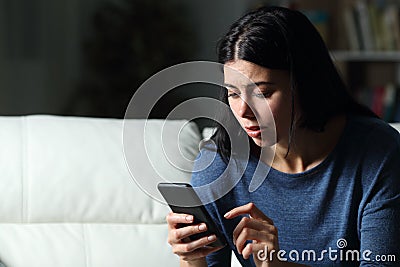 Worried woman checking cell phone text in the night Stock Photo