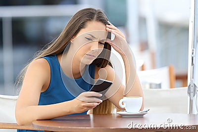 Worried woman holding phone and waiting for a call Stock Photo