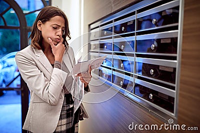 Worried woman looking received letter Stock Photo