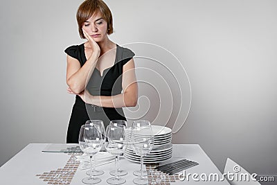 Worried woman setting the table Stock Photo