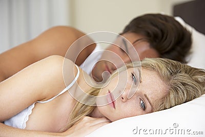 Worried Young Couple In Bed Stock Photo