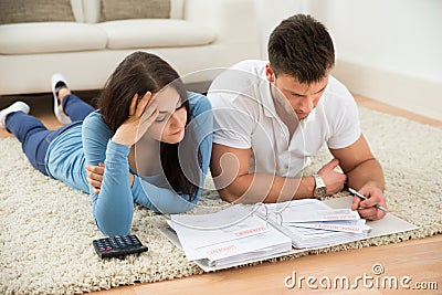 Worried young couple calculating their bills at home Stock Photo