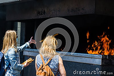 Worshipers throwing the votive candles into the pyre at the Sanctuary of Fatima, Portugal Editorial Stock Photo
