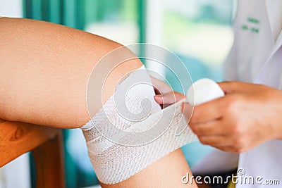 Wound bandaging an injured knee from fall by nurse - first aid leg injury health care and medicine concept Stock Photo