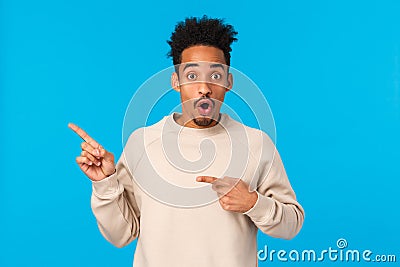 Wow amazing. Impressed and astonished, speechless attractive african-american with afro haircut, hipster guy pointing Stock Photo