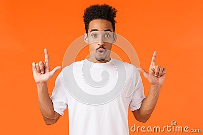 Wow check this out, amazing suggestion. Enthusiastic, intrigued and curious african american male in white t-shirt Stock Photo